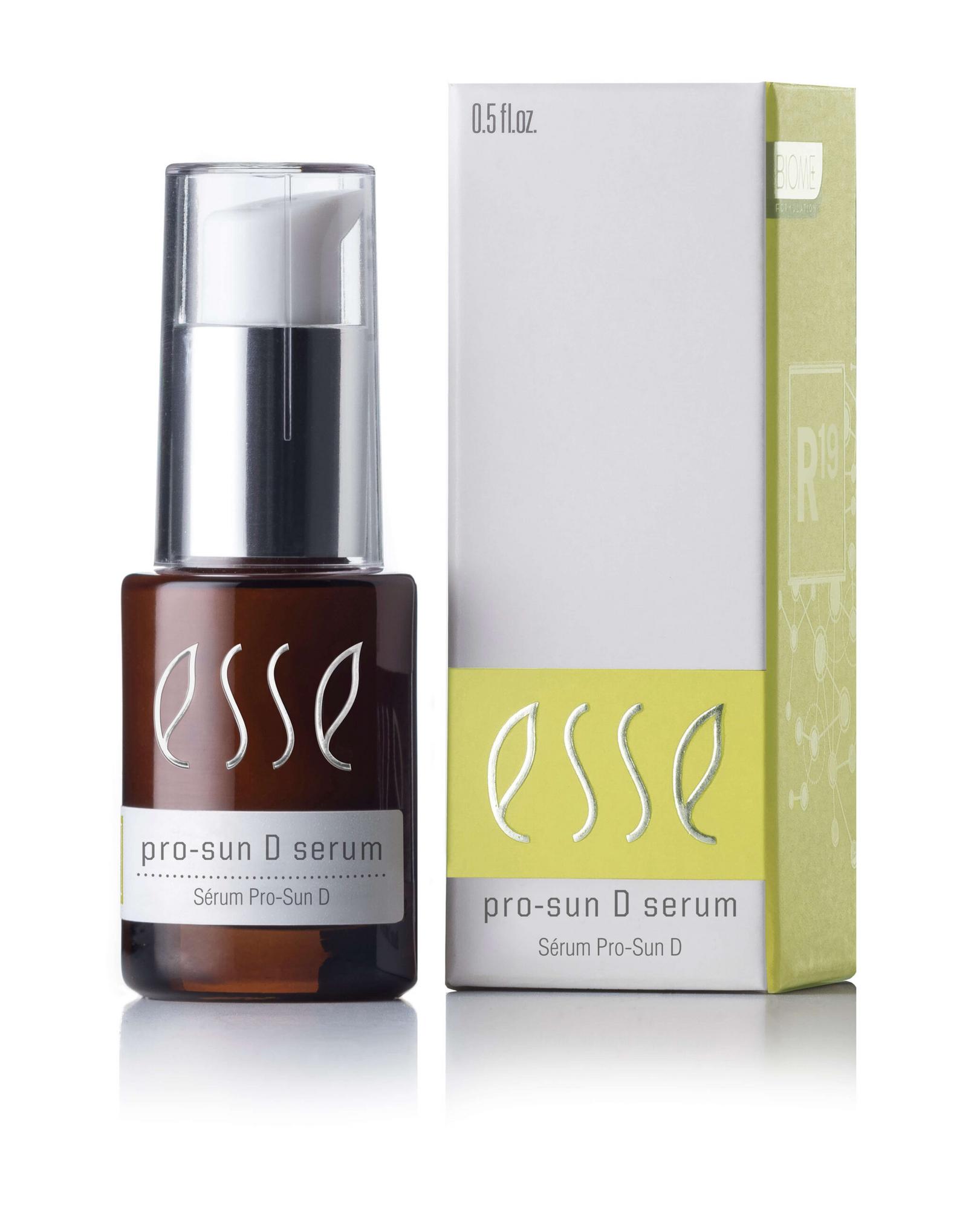 A small brown bottle of Esse Pro-Sun D Serum, featuring a white pump dispenser, stands next to its green and white packaging box which displays the product name and additional text. The bottle contains 0.5 fl oz of serum.